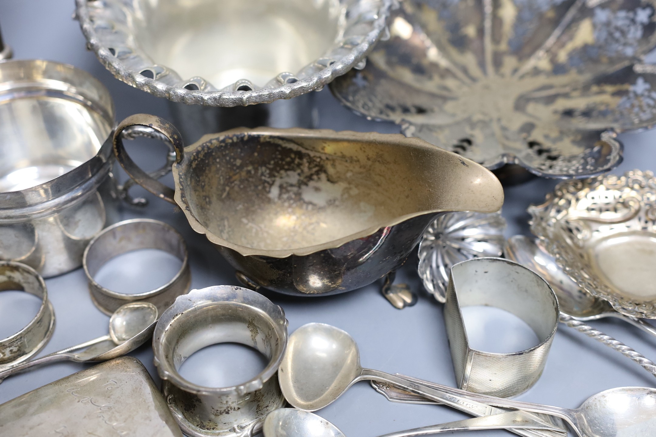 Assorted silver including a pair of posy vases, a small porringer, a pierced shallow bowl, a cigarette case, four napkin rings, a bonbon dish and six silver spoons, together with a French white metal cream jug and three